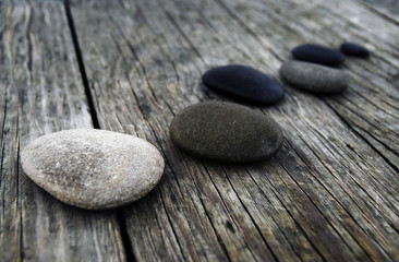 Fototapeta na wymiar Smooth pebbles on an old wooden pier.