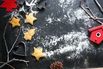 New Year or Christmas background with Xmas decorations and backed cookies on dark wooden chalkboard