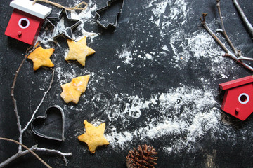 New Year or Christmas background with Xmas decorations and backed cookies on dark wooden chalkboard