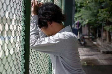 Frustrated stressed young Asian business man feeling disappointed at outside office.