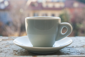 Cup of coffee espresso, on grey grunge stone with blured city background