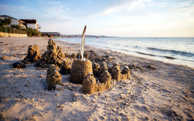 Sand castle on the beach with ornaments made of shells