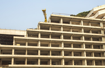 Fototapeta premium a construction crane and a building inscribed uphill.