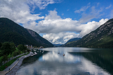 Beautiful landscape Achensee lake, alpine mountains, blue sky and clouds, reflections in water. Tirol, Austria.