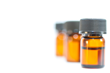 Tiny little brown medical bottles close up shot isolated on white background.