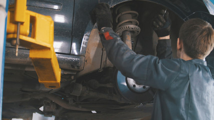 Fototapeta na wymiar Car in auto service lifting for repairing