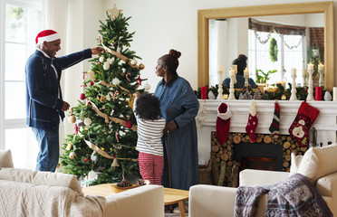 People decorating Christmas tree