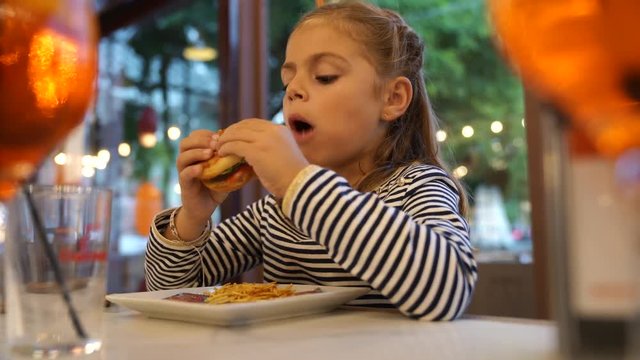 Little girl eating hamburger