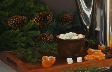 Coffee with marshmallow, mandarins, metal coffee pot and spruce branches on a wooden tray. Christmas and New Year. Still life