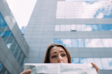 puzzled confused perplexed bewildered woman reading newspaper concept
