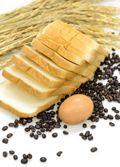 Egg, sliced bread, coffee beans and ears of wheat on white background.