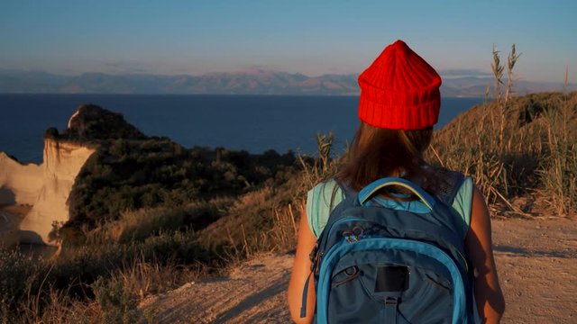 Woman with a backpack goes to the Cape Drastis at Corfu island in Greece