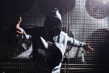 Modern rapper dancing in garage. Urban lifestyle, hip hop. - obrazy, fototapety, plakaty