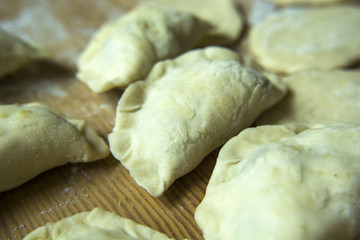Raw dumplings on a wooden board