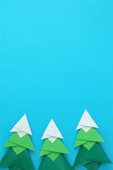 Handmade origami paper craft Christmas tree on blue paper