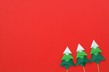 Handmade origami paper craft Christmas tree on red paper