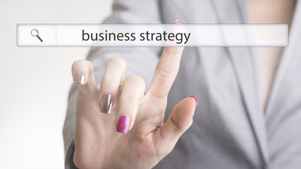Female hand touching a website navigation bar with the text business strategy