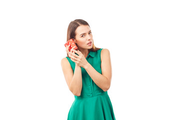 Studio portrait of beautiful young woman holding small gift box on white background