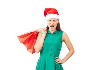Studio portrait of young woman in Santa hat posing with shopping bags on white background