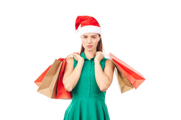 Studio portrait of young woman in Santa hat posing with shopping bags on white background
