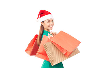 Studio portrait of young woman in Santa hat posing with shopping bags on white background