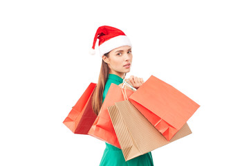 Studio portrait of young woman in Santa hat posing with shopping bags on white background