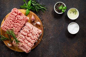 Assorted minced pork and beef with fresh leaves of rosemary and basil. Top view with copy space.