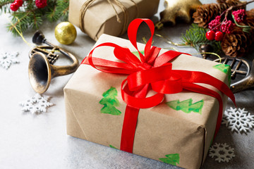 Christmas background. Xmas gift box, branch of a Christmas tree and decorations on a gray stone or slate background.