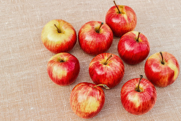 Ripe red-yellow apples lying on a light background.