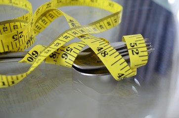 Maßband umwikelt Löffel und Gabel