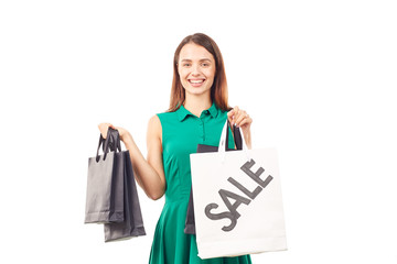 Portrait of female shopaholic holding shopping bags with sale/discount sign