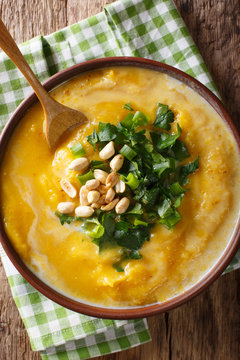 Thai pumpkin curry soup with peanuts and cilantro close-up. Vertical top view