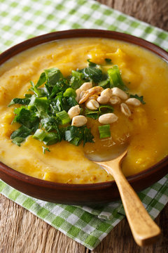 Thai pumpkin curry soup with peanuts and cilantro close-up. vertical