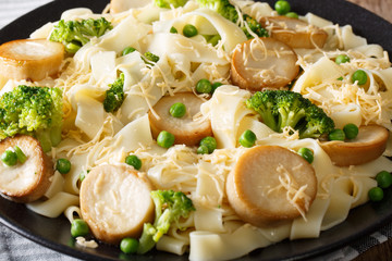 Fettuccine pasta with mushrooms king oyster, broccoli and peas close-up. horizontal