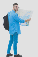 Young man holding at map on white background. Young man holding a map on a white background. A tourist on vacations. Looking for sights. Adventures seeker.