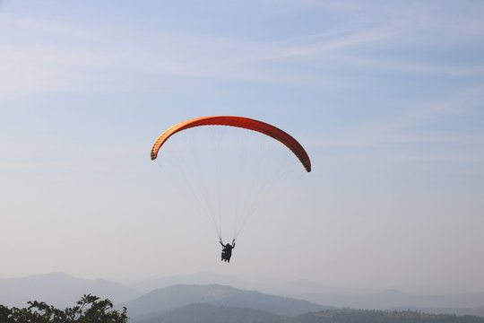  paraglider is flying in the blue sky against the background of clouds. Paragliding in the sky on a sunny day.