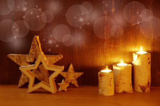 Weihnachten, Christmas, Advent, romantischer Weihnachtshintergrund auf Holz mit Sternen, Kerzen und Bokeh, Textraum, copy space