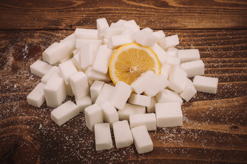 Fresh lemon on bunch of sugar cubes and granulated sugar