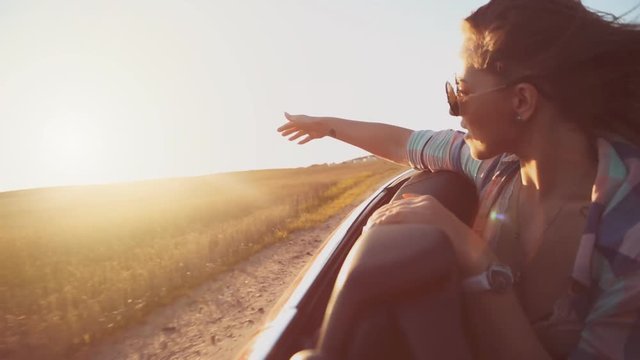 Beautiful girl have fun riding in a red convertible cabriolet car, freedom concept.