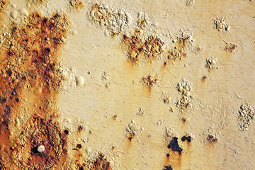 Rust covered weathered iron metal background with yellow peeling blistering paint