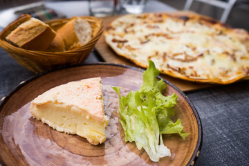 Traditional Alsace regional cheese on dinner table with Flammkuchen