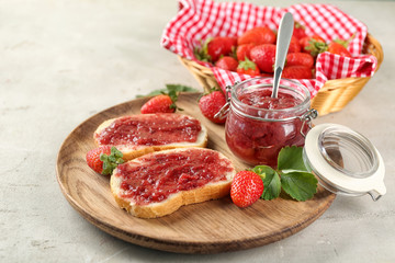 Dish with pieces of bread and strawberry jam on table