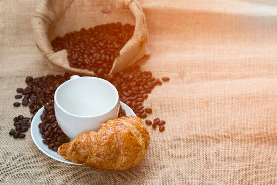 Coffee cup with Croissant and bean which are ready for coffee time