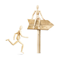 Man rushing in the direction of the road sign. Abstract image with wooden puppets