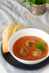 Meatballs in tomato apple sauce served with bread. Rustic style.