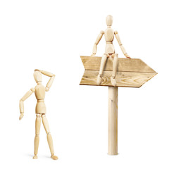 Man watching at the road sign. Abstract image with wooden puppets