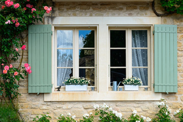 Traditionelles Fenster mit hölzernen Fensterläden und Rosen