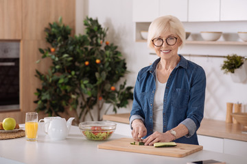 Cheerful senior woman cooking a healthy breakfast