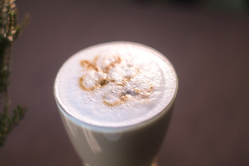 Coffee in a glass cup in a cafe with a blurred background.