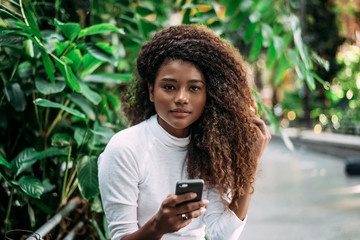 Portrait of beautiful young woman reading text message on mobile phone.
